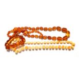 A faceted graduated amber bead necklace, length 91cm; an amber simulant bracelet; two pairs of amber