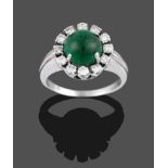 An Emerald and Diamond Cluster Ring, the cabochon emerald within a border of twelve round