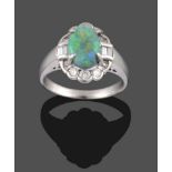 An Opal and Diamond Cluster Ring, the oval opal in a white claw setting, within a surround of