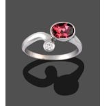 A 9 Carat White Gold Garnet and Diamond Ring, the oval cut garnet collet set to one end of the plain