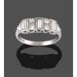 A Diamond Ring, three baguette cut diamonds in white rubbed over settings, alternate with pairs of