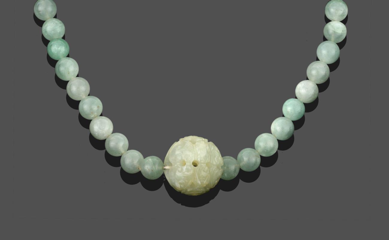 A Jade Necklace, sixty-six spherical jade beads with a larger ornately carved jade bead hung