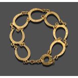 An 18 Carat Gold Horseshoe Motif Bracelet, seven horseshoe motifs chain linked, length 17cm see