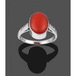 An 18 Carat White Gold Coral and Diamond Ring, the oval cabochon coral in a white collet setting