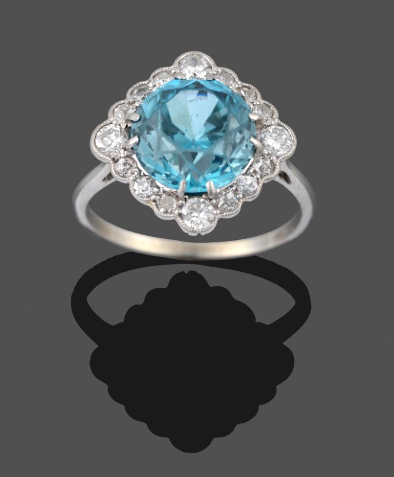 A Blue Zircon and Diamond Cluster Ring, the round cut blue zircon in white claw settings, within a