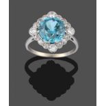 A Blue Zircon and Diamond Cluster Ring, the round cut blue zircon in white claw settings, within a