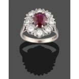 An 18 Carat White Gold Ruby and Diamond Cluster Ring, an oval cut ruby within a border of round