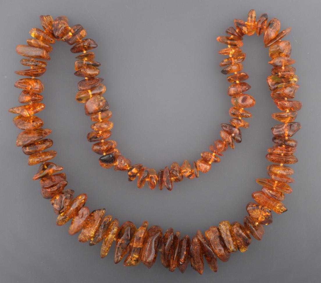 An Amber Necklace, ninety-five irregular shaped and sized orangey-brown amber beads, length 75cm not