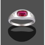 An 18 Carat White Gold Ruby and Diamond Three Stone Ring, the cushion cut ruby and two round