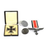 A German Third Reich Iron Cross, First Class, with sword shape pin, in case of issue; three German