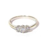 A three stone diamond ring, stamped '18K' and '750', finger size N. Gross weight 2.41 grams.