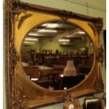 A reproduction gilt composition oval mirror, 123cm by 150cm