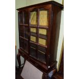 An oak glazed cabinet on stand, with two doors enclosing adjustable shelves, raised on a stand