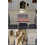 A cream dressing table with six drawers; two cream dressing table mirrors; a dressing table stool; a