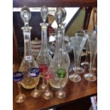 Four tall glass decanters (1 x A/F), five tall stemmed port glasses with coloured bowls and five