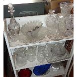 Three shelves of old cut glass decanters, jugs, vases, etc.