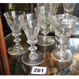 Pair of faceted wine glasses on black knop stem and a pair of wine glasses on capstan stems