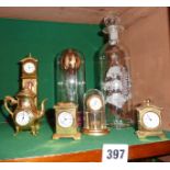 Five miniature brass novelty clocks and two Mayflower glass sculptures