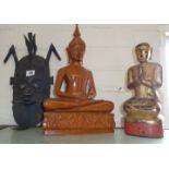 African metal wall mask, a carved wood Buddha and a giltwood similar