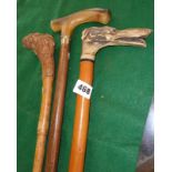 Three various walking sticks one with dog's head handle