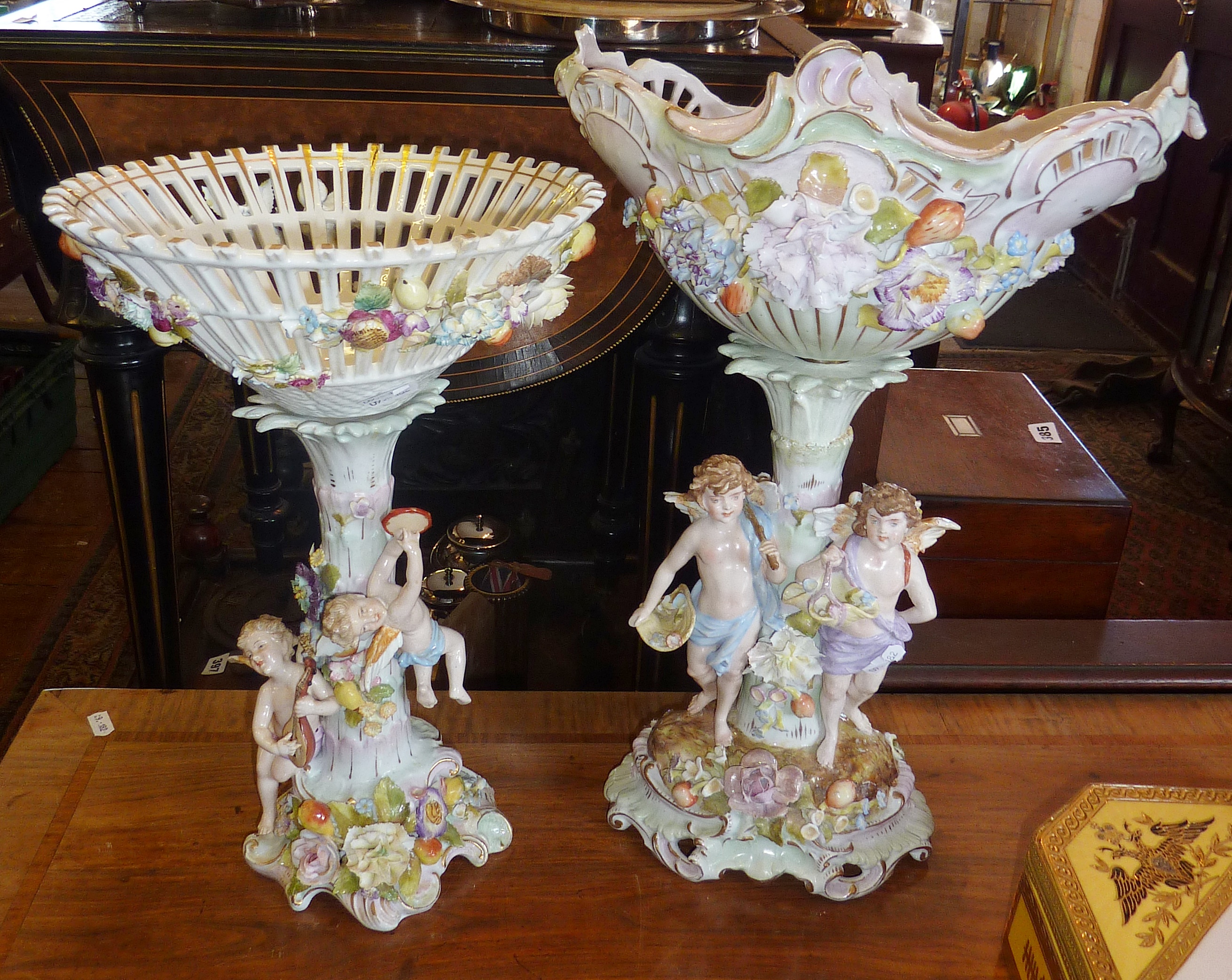 Austrian or German porcelain figural centrepieces, decorated with cherubs and flowers (both