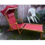 A reclining deck chair with canopy and foot rest