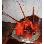 Five various old oil cans on a tray