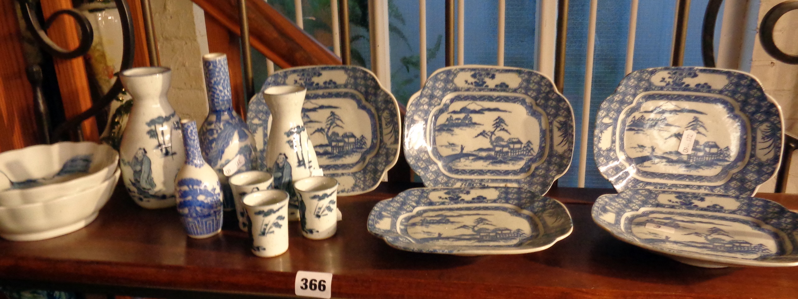 Shelf of assorted Oriental blue and white china vases and dishes inc. Sake bottles and Chinese