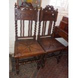 Pair of Victorian oak hall chairs with barley-twist supports above carved solid seat
