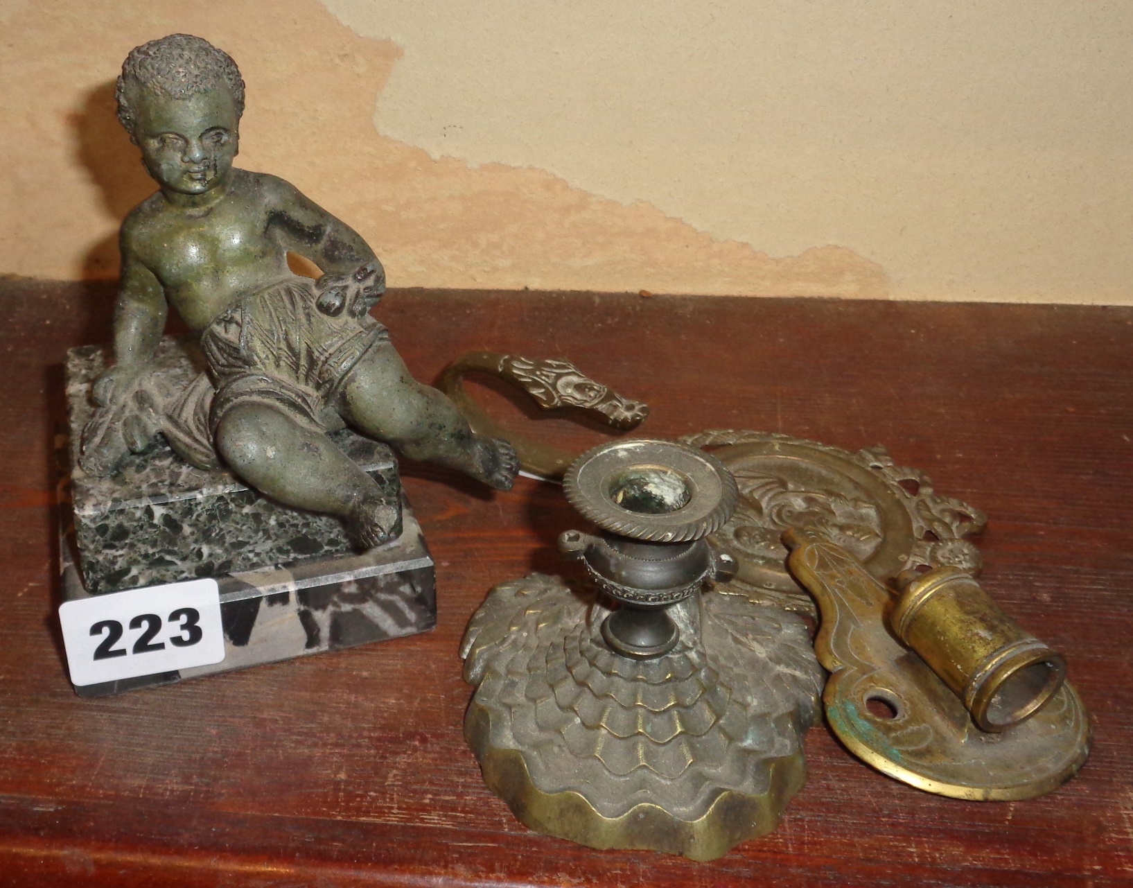 Putti figure set on marble plinth, an ornate brass tie-back and two other brass items