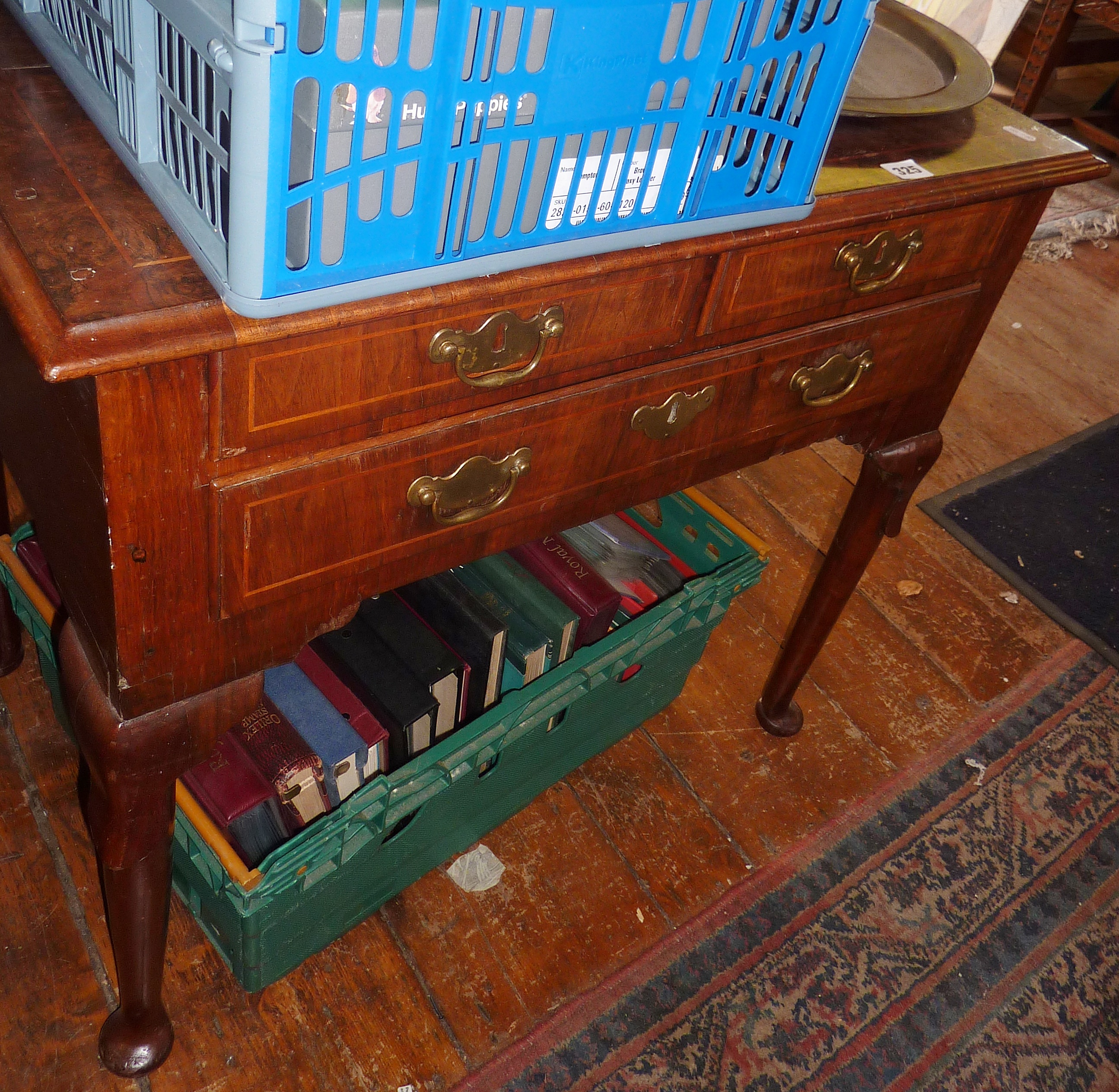 Georgian walnut lowboy having three drawers with brass handles and escutcheons, standing on tapering