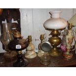 Four various oil lamps and three onyx table lamps