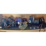 Nine assorted vintage cameras, a light meter and a lens