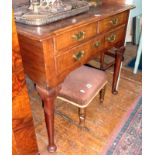 Georgian walnut lowboy having three drawers with brass handles and escutcheons, standing on tapering