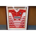 A mounted and framed signed Wigan Warriors Rugby shirt bearing players' signatures from the 1990's