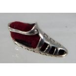 A silver pin cushion in the form of a shoe,