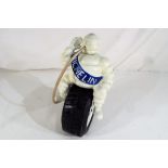 A Michelin man sitting on a tyre approx 24cm (h) Est £20 - £30