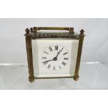 An early 20th century carriage clock, brass and glass cased, white enamel dial in good codition,