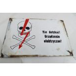 An enamelled sign featuring a skull with Polish writing which translates as 'Do Not Touch the