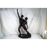 A large bronzed figure depicting a lady and gentleman,