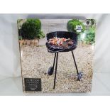 An outdoor round charcoal barbecue,