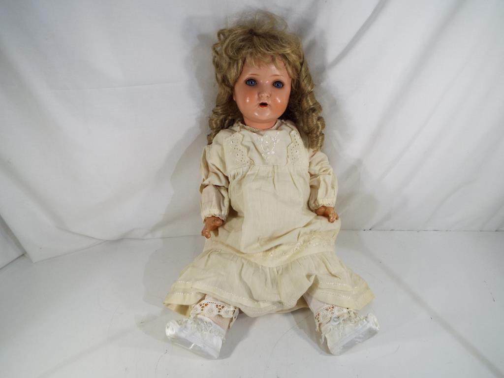 A bisque headed dressed doll with glass sleeping eyes, open hand painted mouth, with jointed limbs,