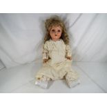 A bisque headed dressed doll with glass sleeping eyes, open hand painted mouth, with jointed limbs,
