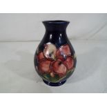 Moorcroft Pottery - a small Moorcroft Pottery vase decorated with freesia on a blue ground stamped