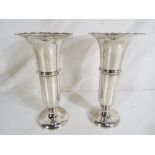 A pair of George V silver hallmarked vases of tapering form with everted rim and central rib,