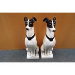 A pair of large garden statues depicting greyhounds sat on separate plinths approx 65cm (h) Est £60