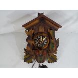 A German carved wood two weight cuckoo clock, Roman numerals to the dial, carved rabbit,