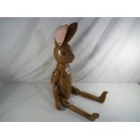 A large wooden shelf rabbit with jointed limbs Est £35 - £50