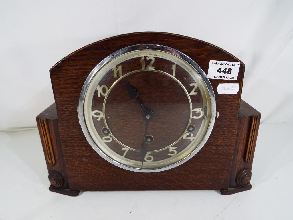 An oak cased mantle clock Arabic numerals chapter ring,