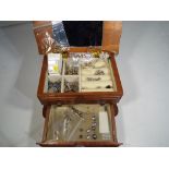 A wooden jewellery box containing a quantity of paired earrings,